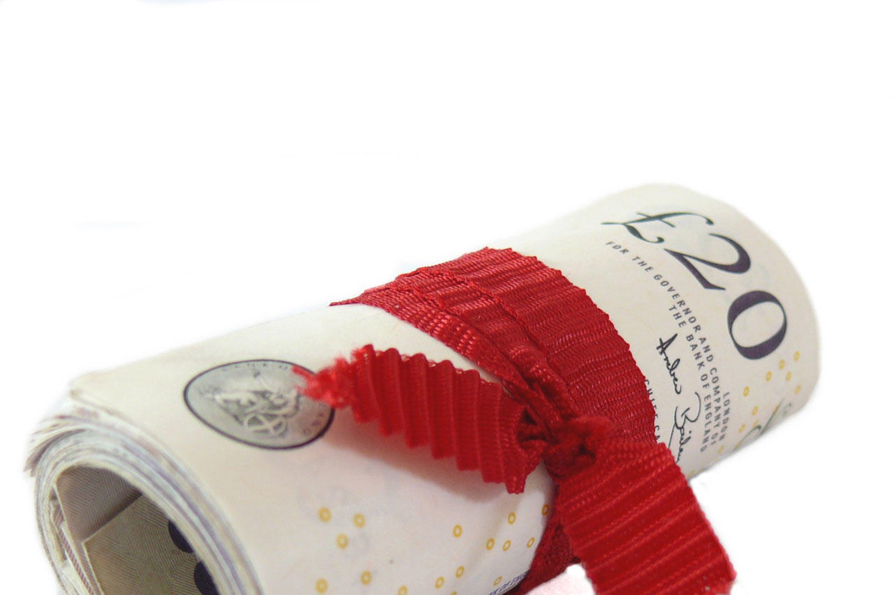A roll of UK notes. Doing well in economics classes could benefit you financially in the long-term.